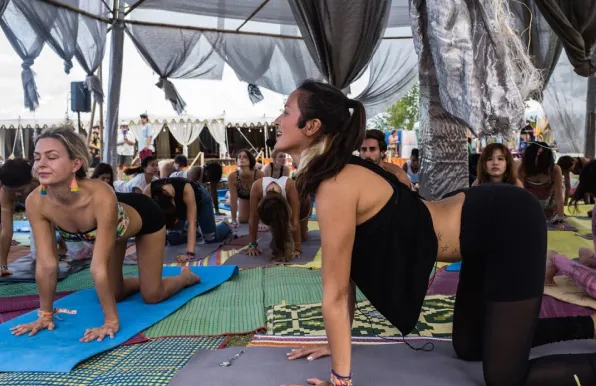 Selin instructing a large group of people for a Yoga session during \x22Wonderfruit\x22